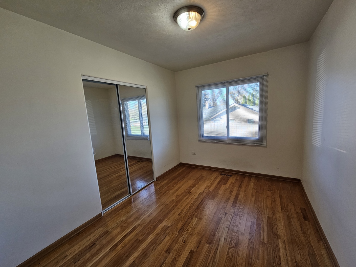 811 Hoyle Road Lombard, IL 60148 - Photo 10 of 22 an empty room with wooden floor and windows