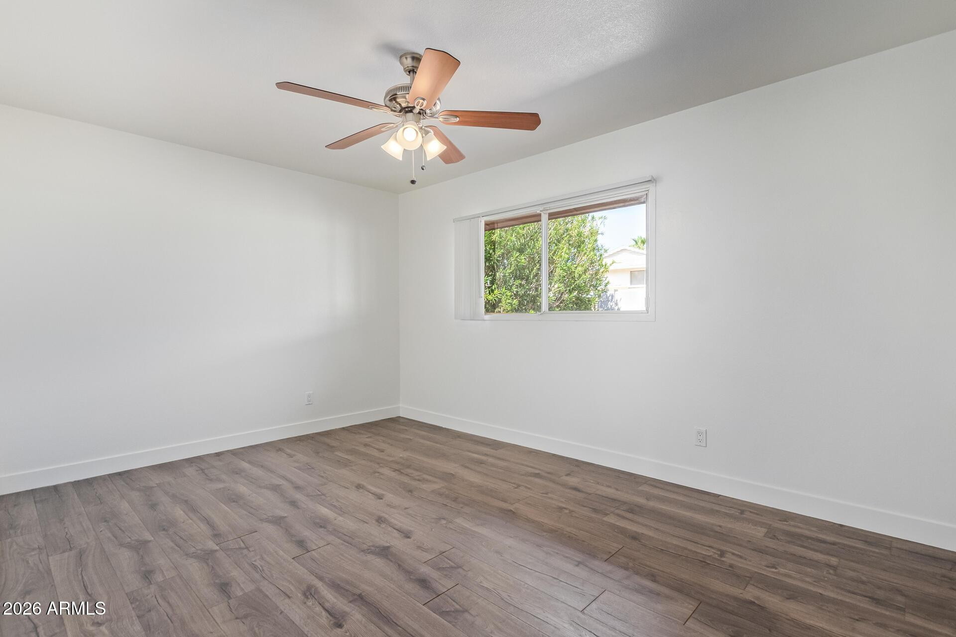 3929 South Pine Street Tempe, AZ 85282 - Photo 12 of 23 an empty room with wooden floor fan and windows
