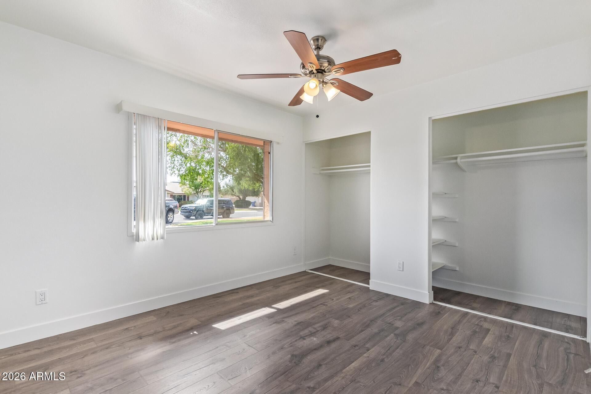 3929 South Pine Street Tempe, AZ 85282 - Photo 15 of 23 an empty room with wooden floor fan and windows