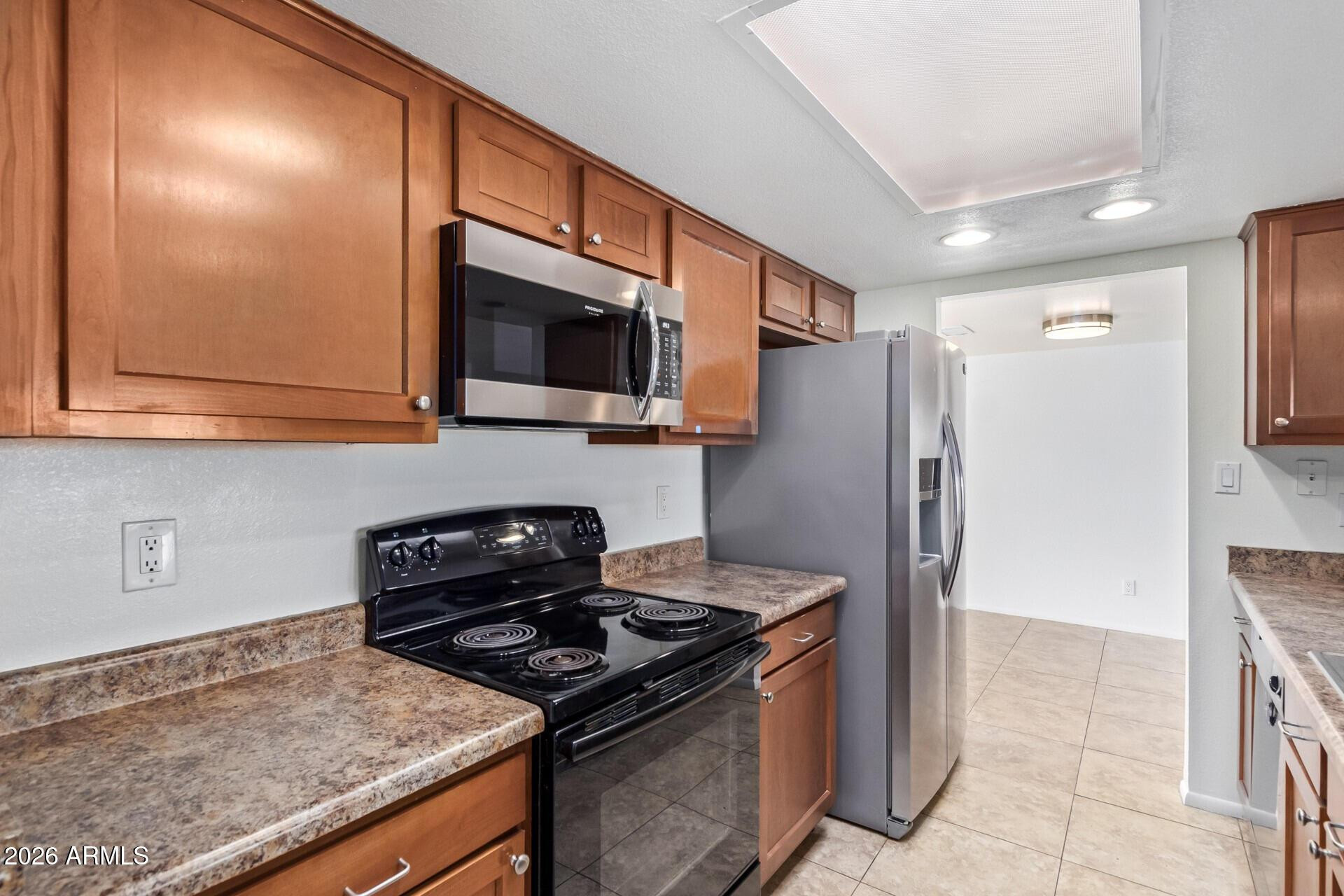 3929 South Pine Street Tempe, AZ 85282 - Photo 7 of 23 a kitchen with stainless steel appliances granite countertop a stove top oven a refrigerator and a sink