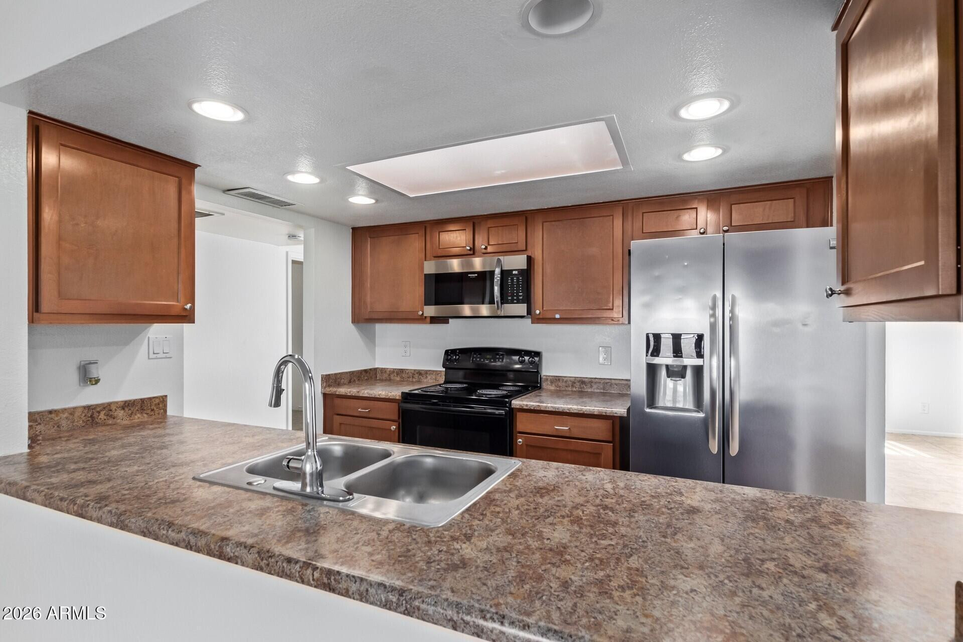 3929 South Pine Street Tempe, AZ 85282 - Photo 8 of 23 a kitchen with granite countertop a refrigerator and a sink