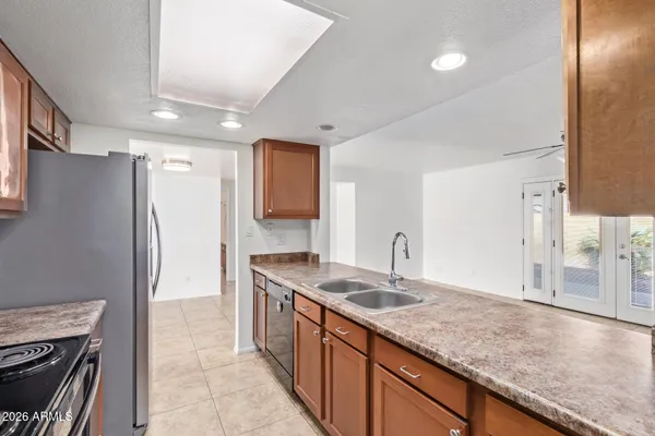 a kitchen with granite countertop a sink stove and refrigerator