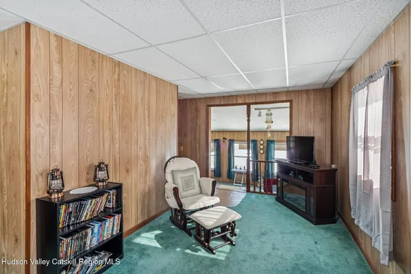 a living room with furniture a flat screen tv and a window