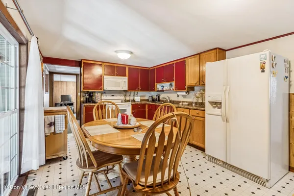 a kitchen with stainless steel appliances a refrigerator a stove a sink and white cabinets with wooden floor