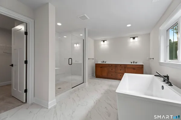a bathroom with a tub a sink and mirrors
