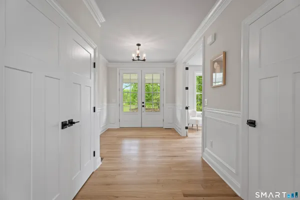 a view of a hallway with wooden floor and closet area