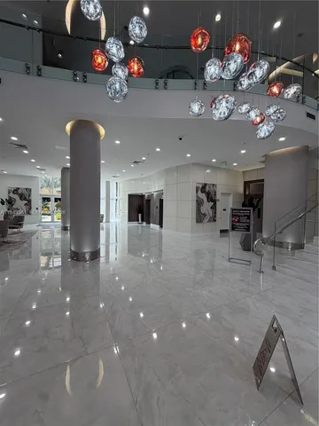 a lobby with a chandelier furniture and a potted plant