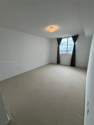 an empty room with a window and fireplace