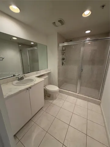 a bathroom with a double vanity sink toilet and shower