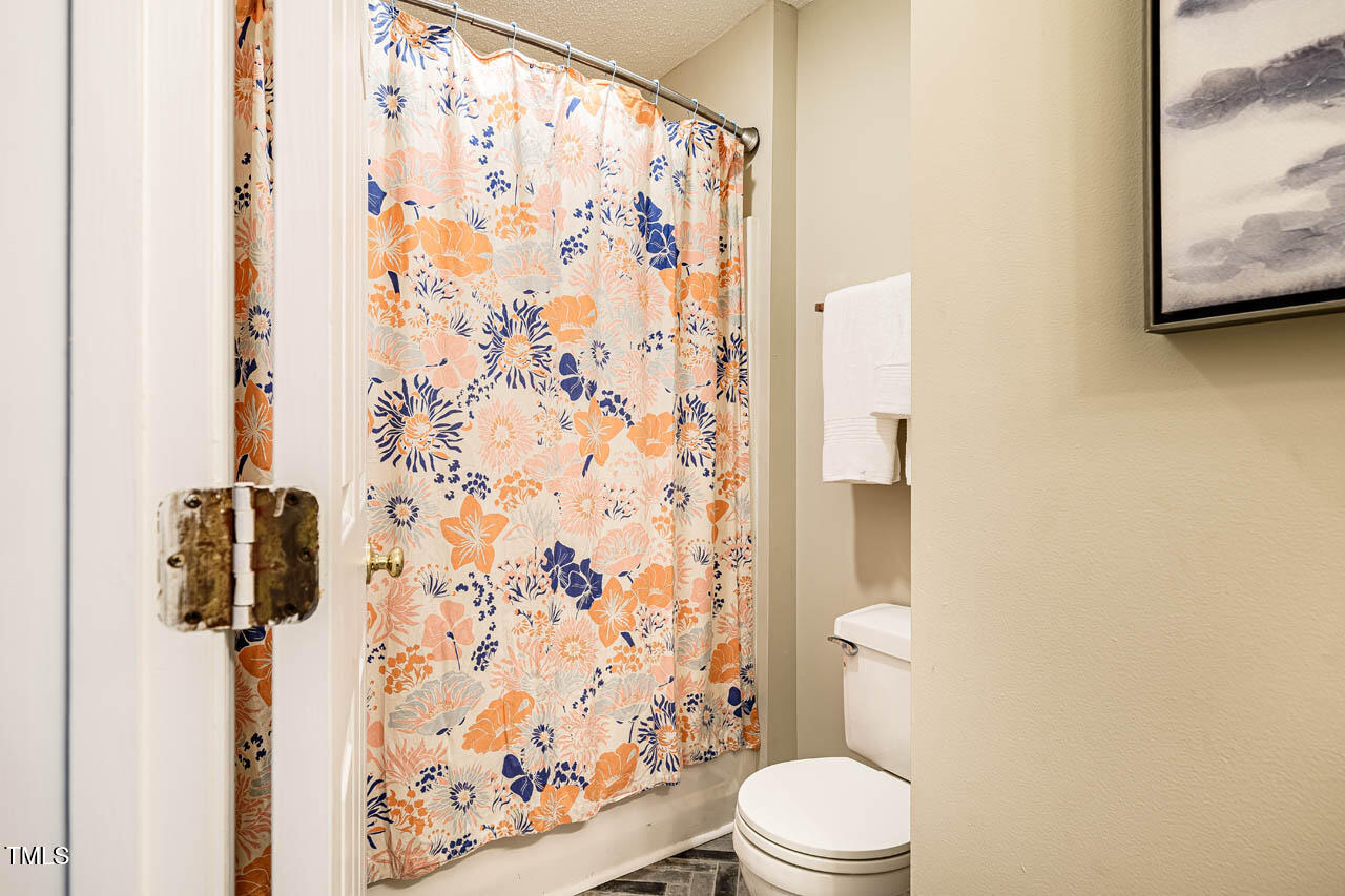 3 Little Stone Circle Durham, NC 27703 - Photo 17 of 27 a white toilet sitting next to a shower curtain