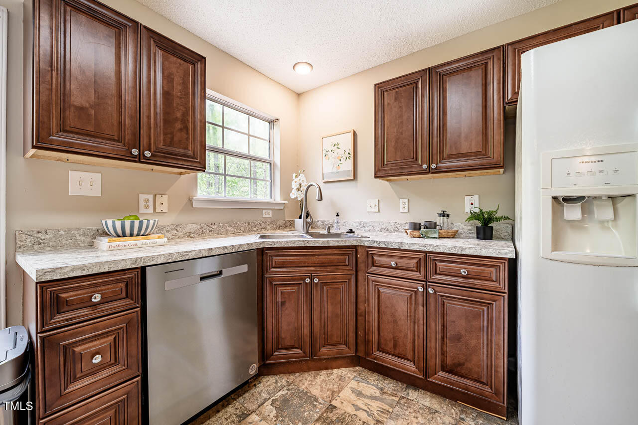 3 Little Stone Circle Durham, NC 27703 - Photo 10 of 27 a kitchen with granite countertop wooden cabinets stainless steel appliances a sink and window