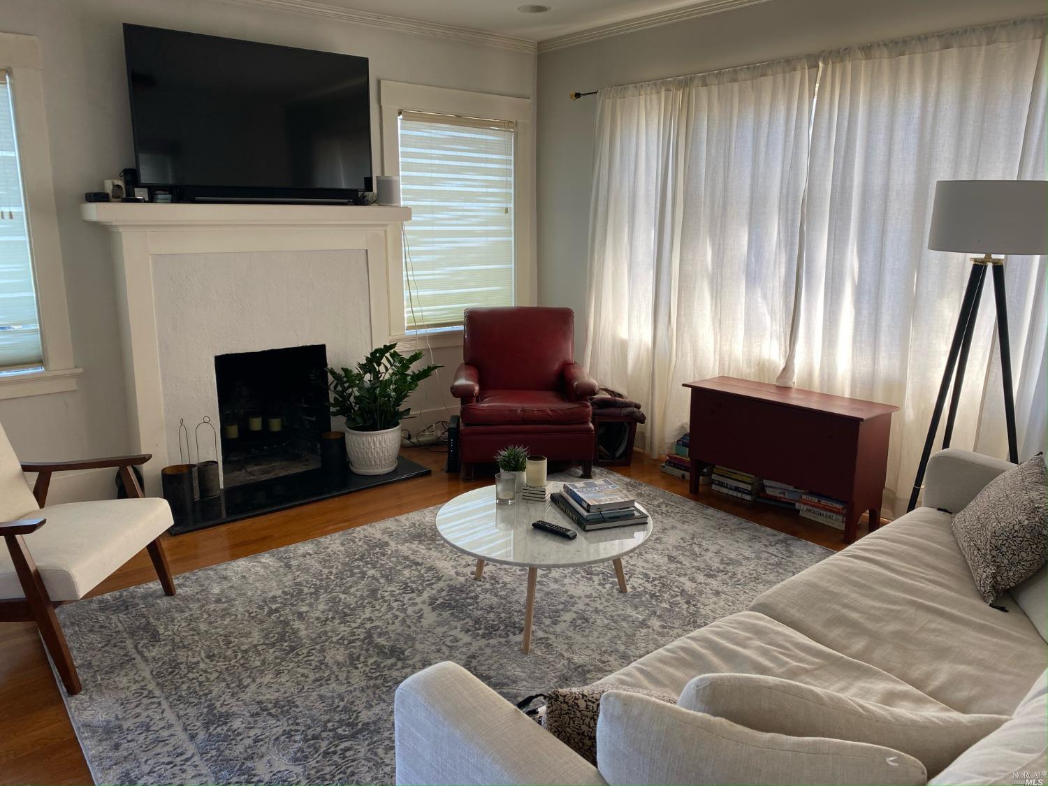 6 West Court, Unit B Sausalito, CA 94965 - Photo 5 of 9 a living room with furniture a fireplace and a flat screen tv
