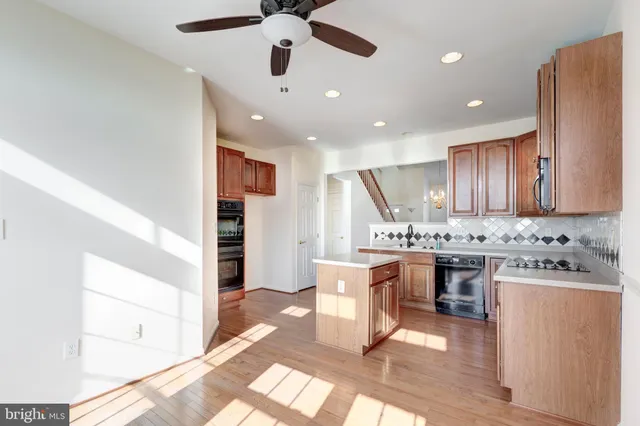 a kitchen with kitchen island stainless steel appliances a sink stove and cabinets