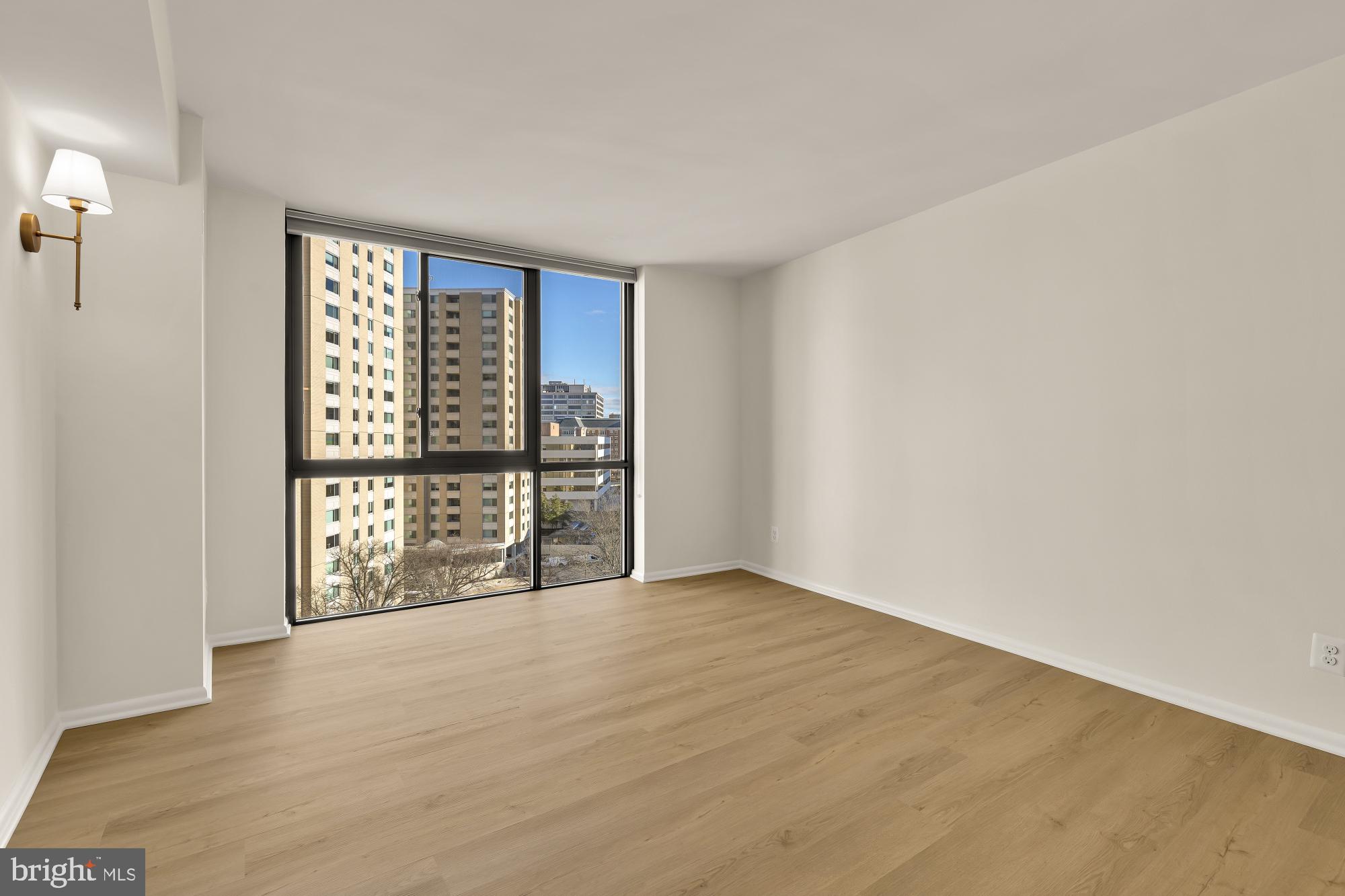 4620 North Park Avenue, Unit 1211E Chevy Chase, MD 20815 - Photo 16 of 37 a view of an empty room with wooden floor and a window