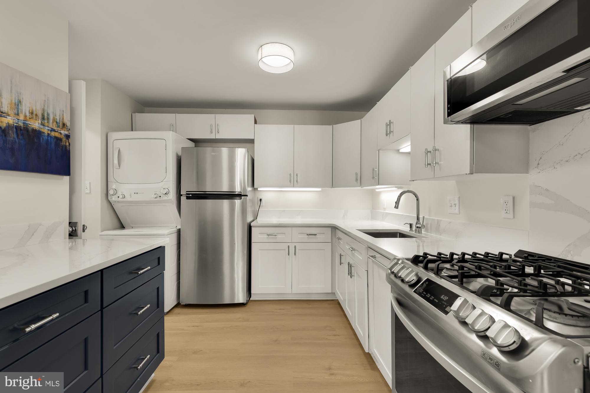 4620 North Park Avenue, Unit 1211E Chevy Chase, MD 20815 - Photo 7 of 37 a kitchen with stainless steel appliances granite countertop a sink stove and refrigerator