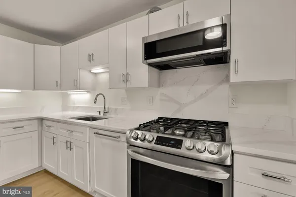 a kitchen with white cabinets and appliances