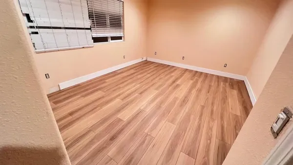 a view of a room with wooden floor and cabinet
