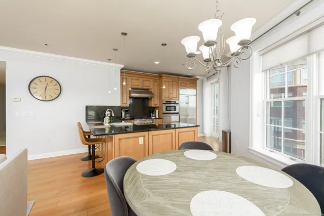 a kitchen with stainless steel appliances kitchen island granite countertop a table and chairs