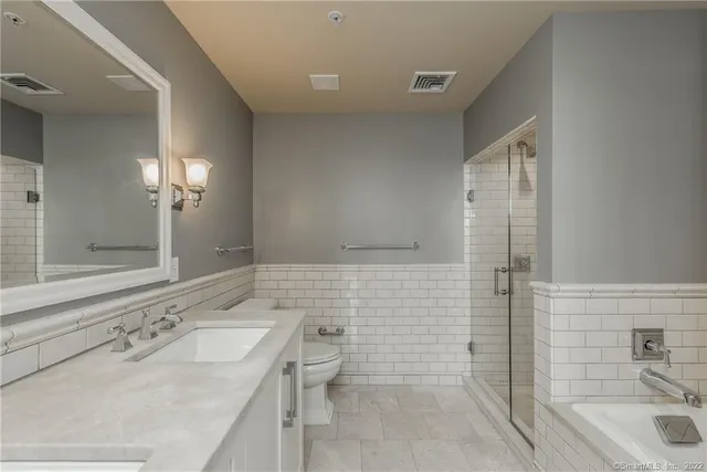 a bathroom with a sink mirror toilet and bathtub