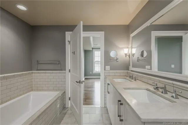 a bathroom with a tub sink and mirror