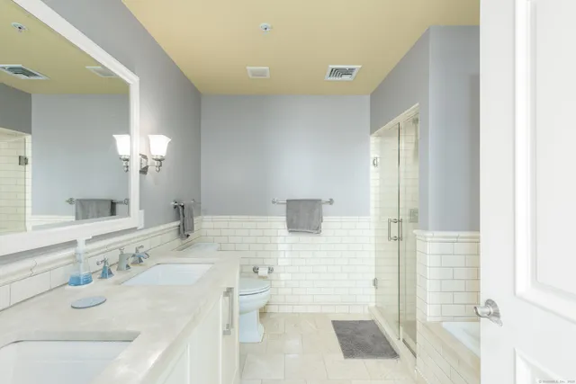 a bathroom with a granite countertop sink toilet and shower