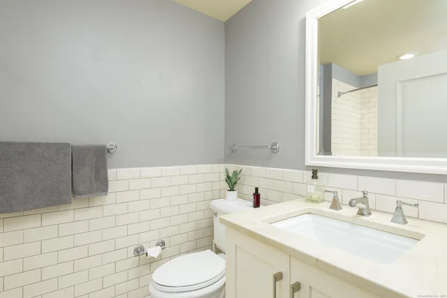a bathroom with a sink toilet and mirror