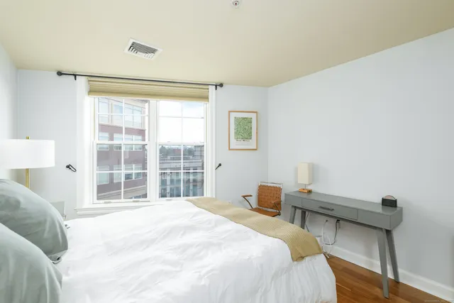 a bedroom with a bed and a large window