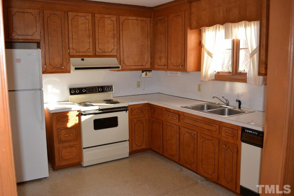 2808 Glen Burnie Drive Raleigh, NC 27607 - Photo 19 of 23 a kitchen with granite countertop white cabinets and white appliances