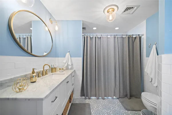 a bathroom with a sink a toilet and a mirror