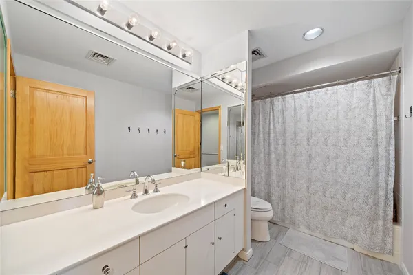 a bathroom with a double vanity sink toilet and a shower