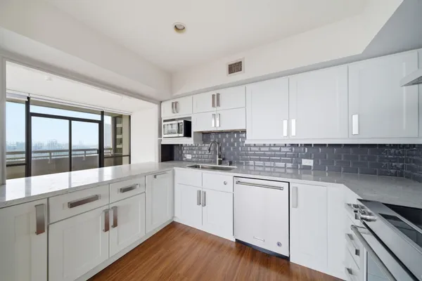 a kitchen with white cabinets and white appliances