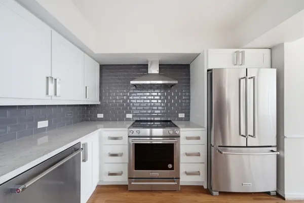a kitchen with white cabinets and white appliances
