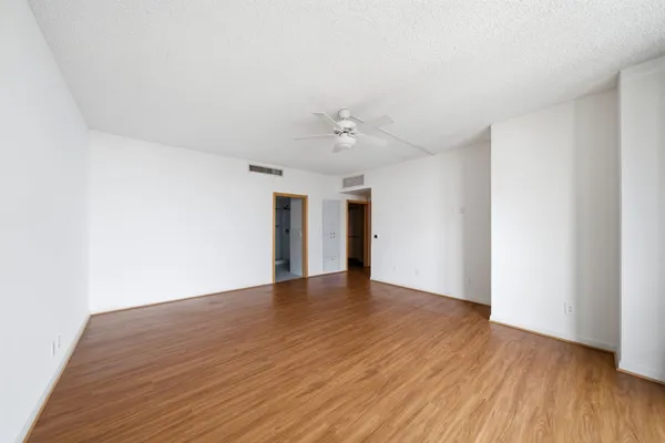a view of an empty room with wooden floor