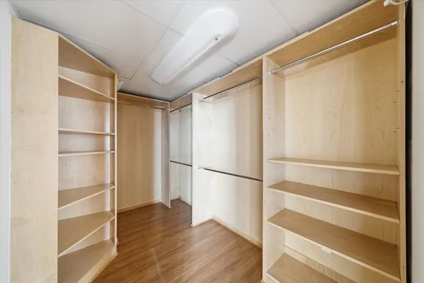 a view of walk in closet with empty racks