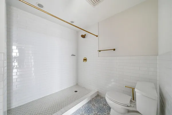 a bathroom with a granite countertop bathtub shower and toilet