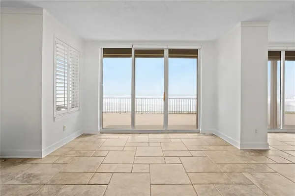 a view of an empty room with window and hardwood floor