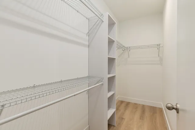 a view of walk in closet with empty racks