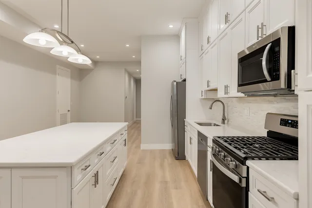a kitchen with stainless steel appliances a stove microwave and a refrigerator