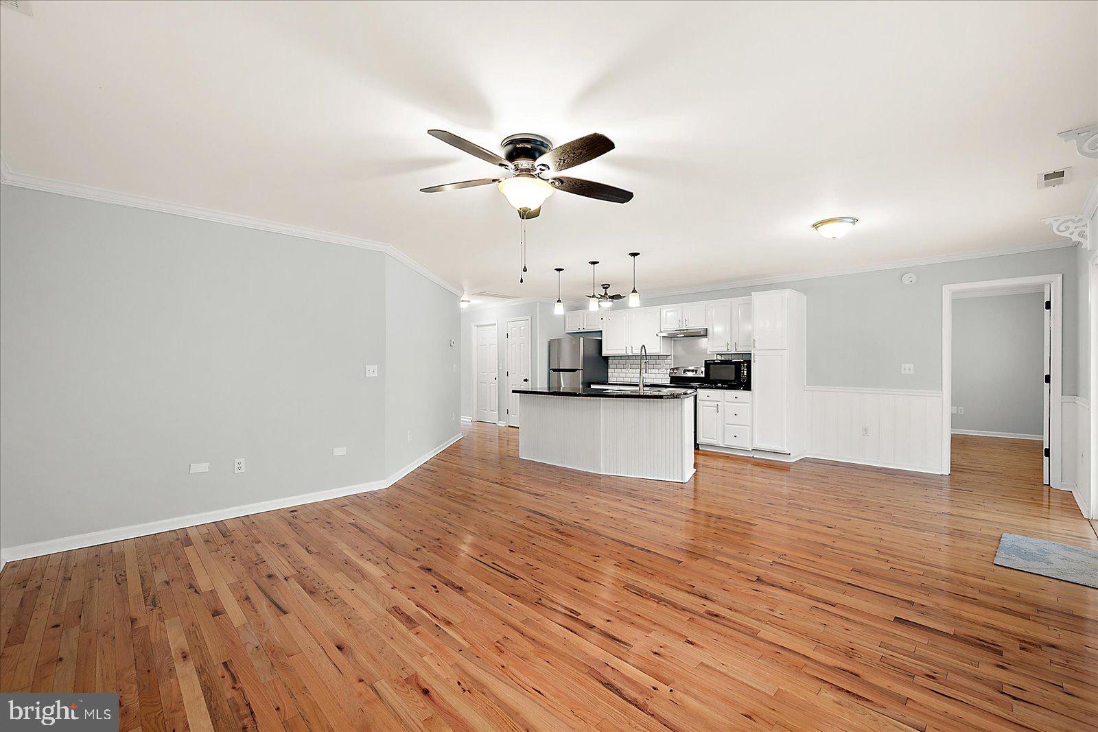 36405 Poplar Neck Road Willards, MD 21874 - Photo 11 of 50 a view of a kitchen with wooden floor and a ceiling fan