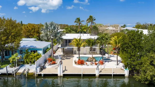 a view of a chairs and table in patio with a lake view