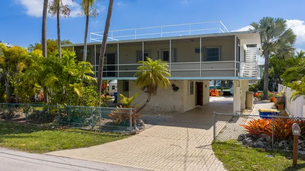 a view of a patio with table and chairs and potted plants