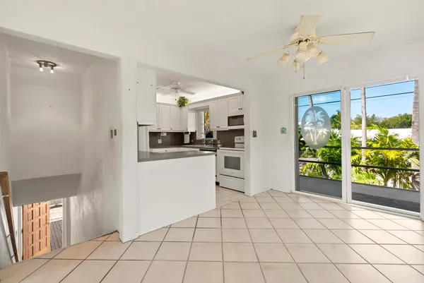 a bathroom with a granite countertop sink a toilet and a window