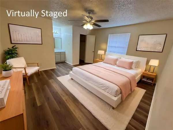 a view of an empty room with wooden floor and a ceiling fan