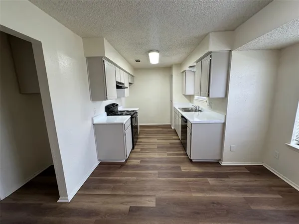 a kitchen with a sink a stove and a refrigerator