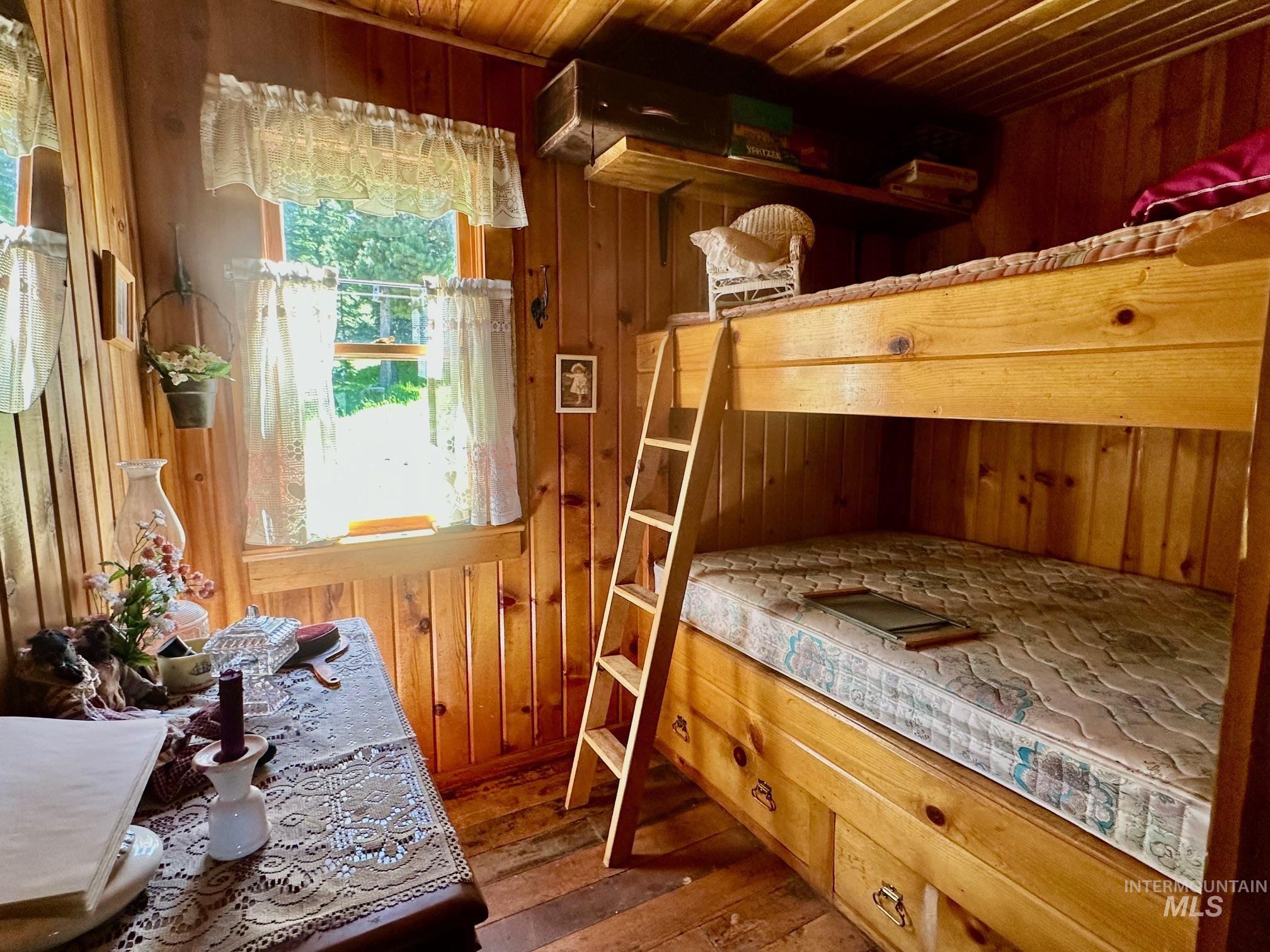 509 Deadline Road, Unit 2 Twin Falls, ID 83301 - Photo 17 of 28 Room featuring natural wood paneling throughout, a built-in bunk bed with integrated drawers, and a ladder for upper bunk access