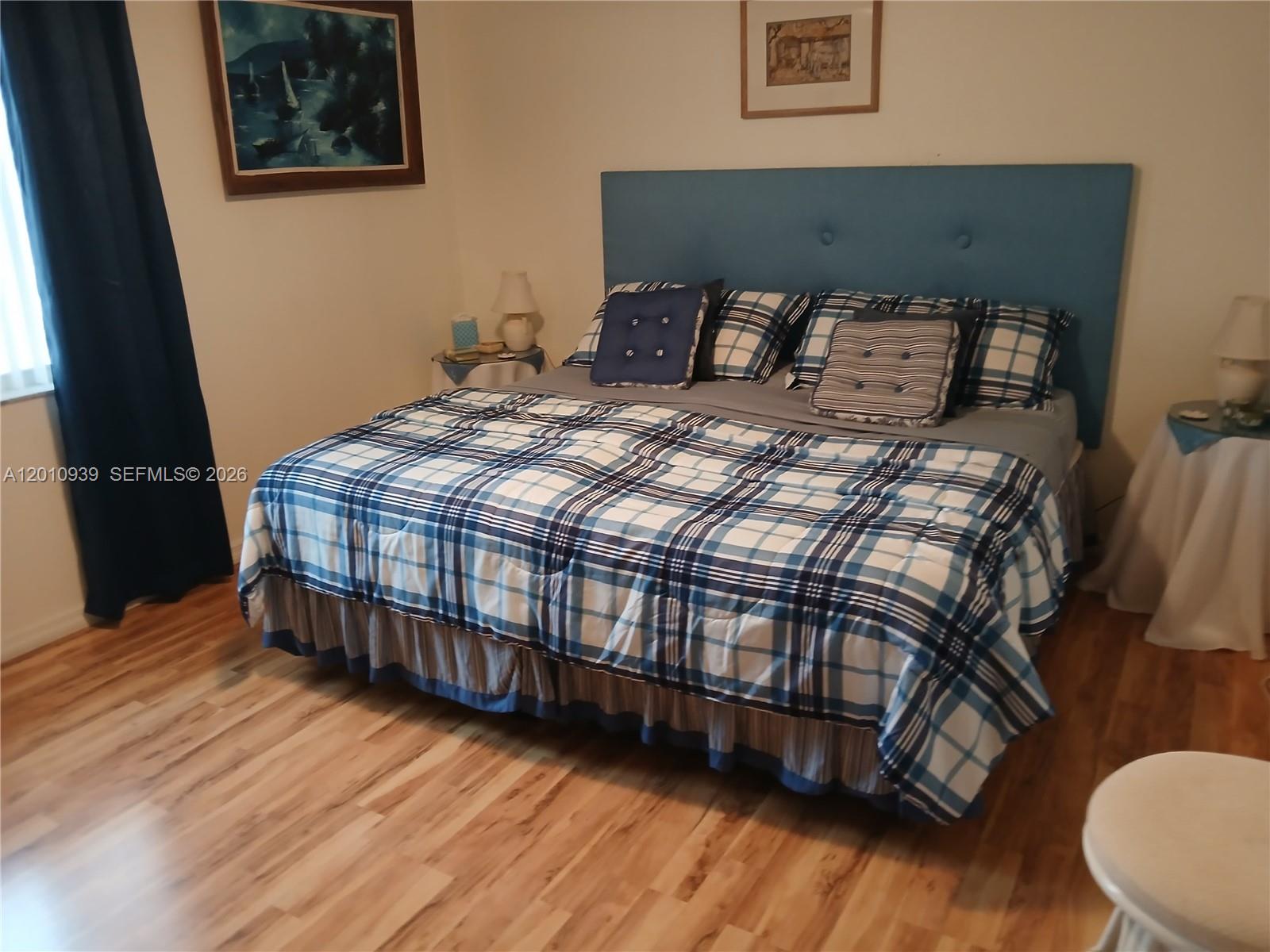 5880 Southwest 102nd Street Ocala, FL 34476 - Photo 11 of 17 a bedroom with a bed window and wooden floor