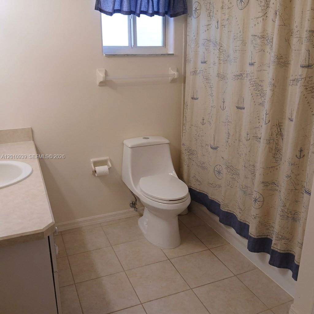 5880 Southwest 102nd Street Ocala, FL 34476 - Photo 12 of 17 a white toilet sitting next to a shower curtain