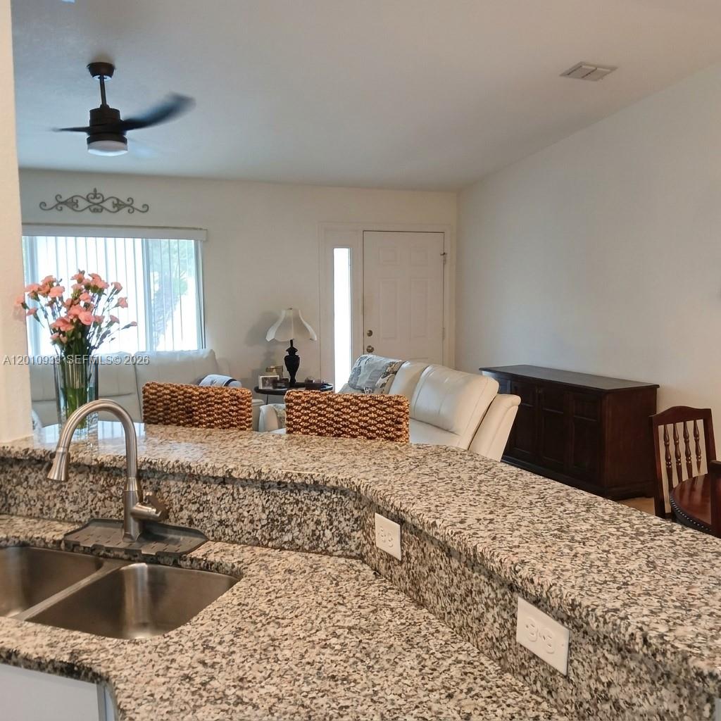 5880 Southwest 102nd Street Ocala, FL 34476 - Photo 6 of 17 a kitchen with a sink granite counter tops and a view of living room