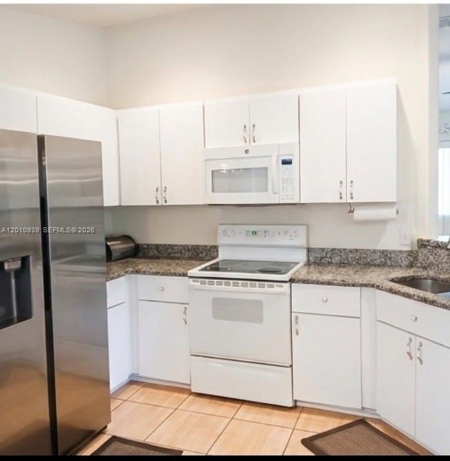 5880 Southwest 102nd Street Ocala, FL 34476 - Photo 7 of 17 a kitchen with granite countertop white cabinets and white appliances