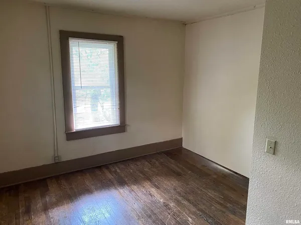 a view of a room with wooden floor and window